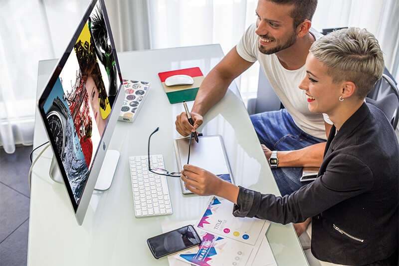Allievo al Mac durante un progetto di grafica pubblicitaria, aula AreaDomani