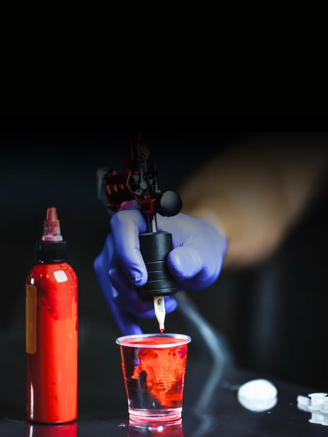 Tatuatore concentrato al lavoro su un tatuaggio, corso professionale AreaDomani